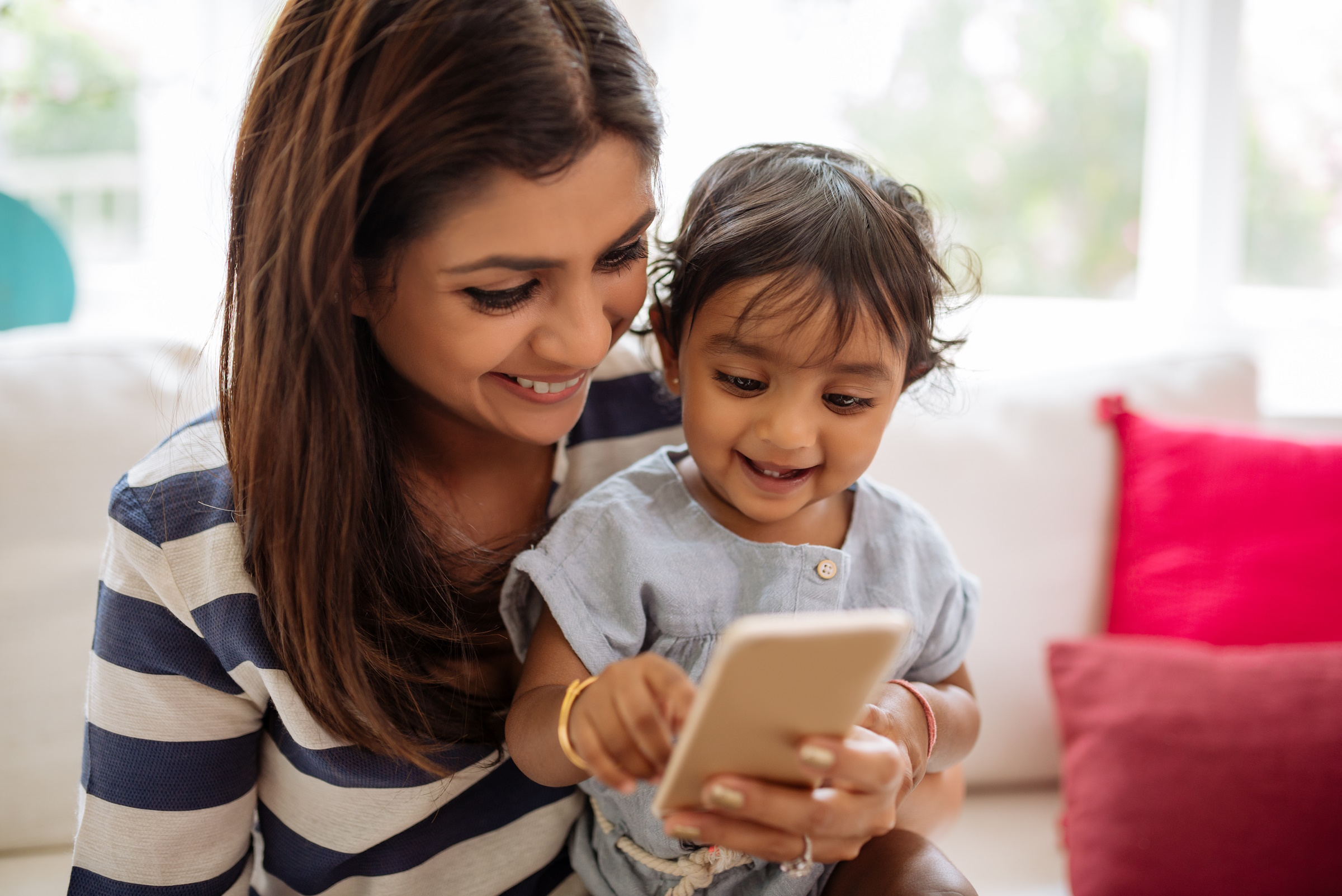 Indian mother and child playing game on the smartphone